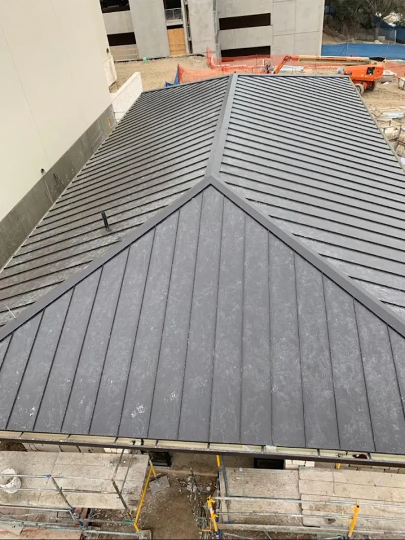 Commercial metal roof construction with crane equipment in Rensselaer